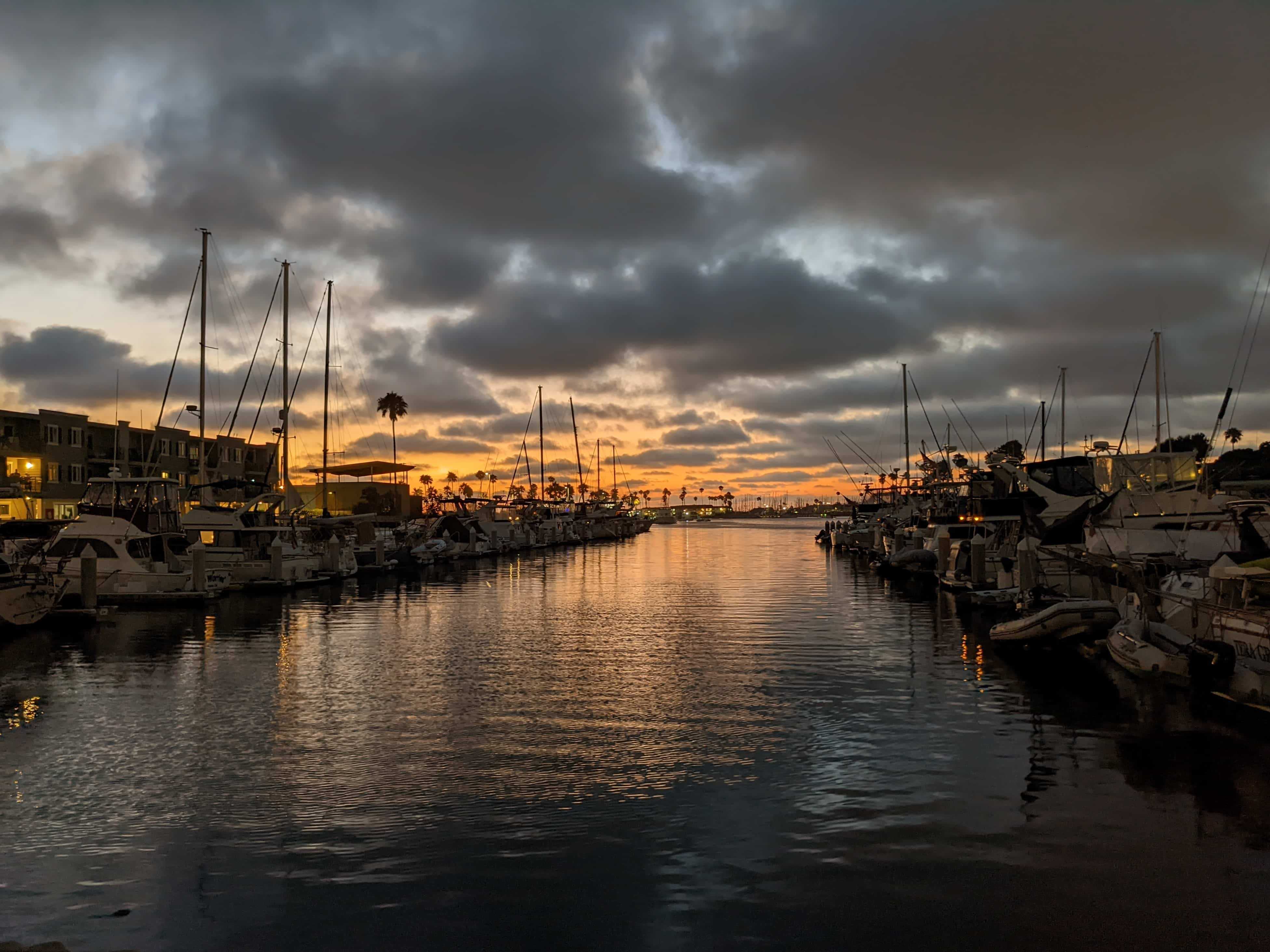 a sunset over a harbor full of boats.
