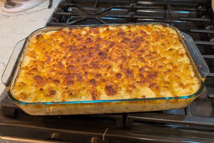 A pan on the stove with broiled mac and cheese.