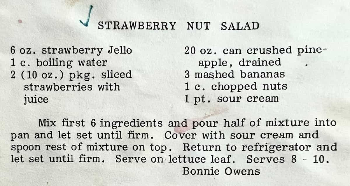 Printed recipe titled 'Strawberry nut salad'. Ingredients: 6 oz. strawberry Jello, 1 c. boiling water, 2 (10 oz.) pkg. sliced, strawberries with juice, 20 oz. can crushed pine-apple, drained, 3 mashed bananas, 1 c. chopped nuts, 1 pt. sour cream. Directions: Mix first 6 ingredients and pour half of mixture into pan and let set until firm. Cover with sour cream and spoon rest of mixture on top. Return to refrigerator and let set until firm. Serve on lettuce leaf. Serves 8 10. Bonnie Owens