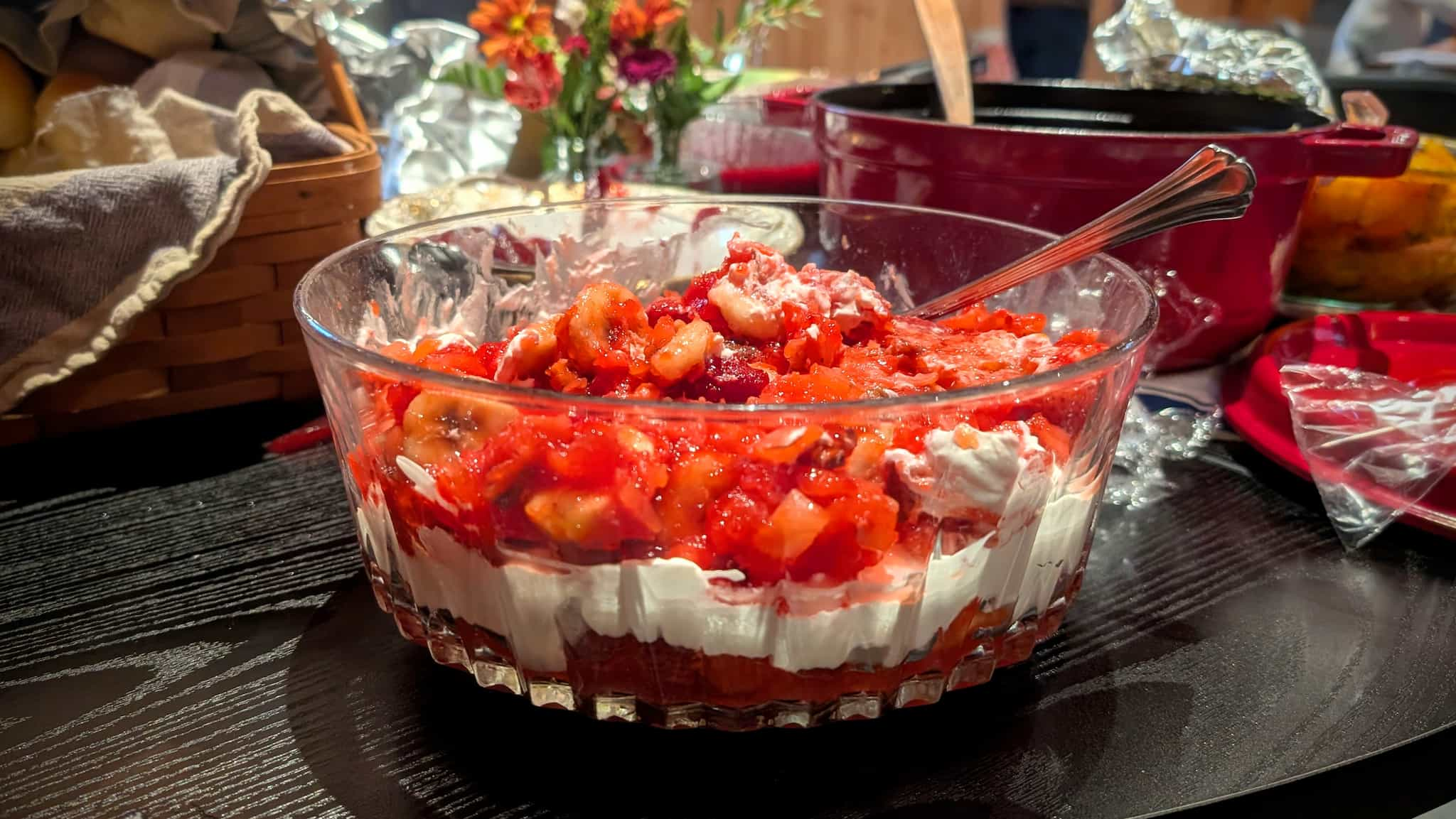 Glass bowl with red fruit mixture with a while cream layer.