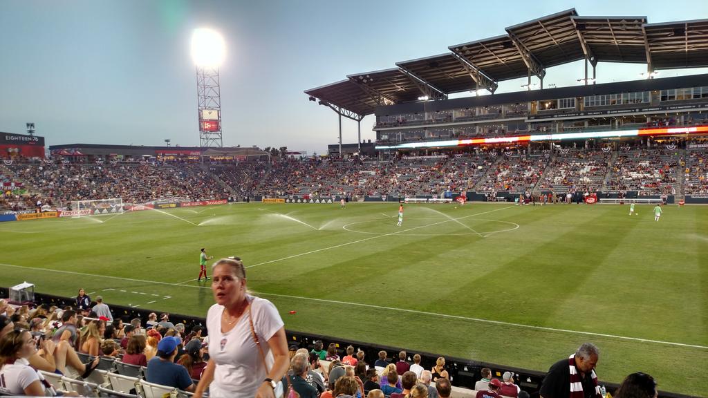 View of a professional soccer field from the stand with sprinklers running.